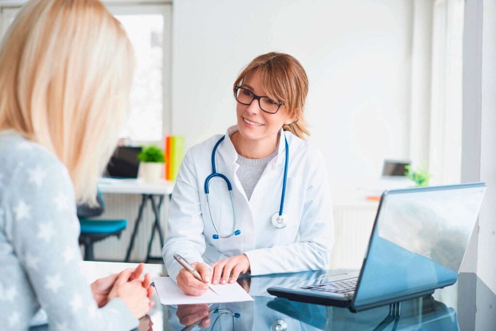 Doctor consulting with patient in a medical clinic – personalized care interaction highlighted for wellness marketing effectiveness.